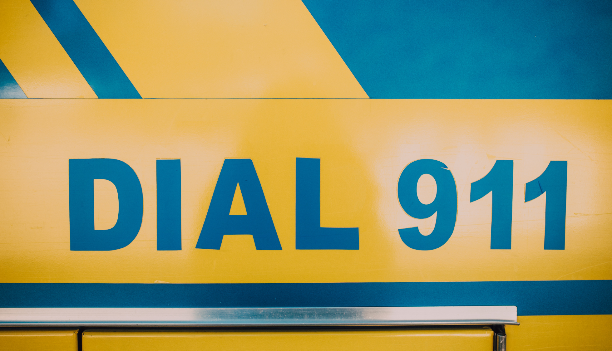 blue and yellow image of the words "dial 911"