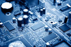 Close-up of a blue-tinted electronic circuit board with various chips and components.