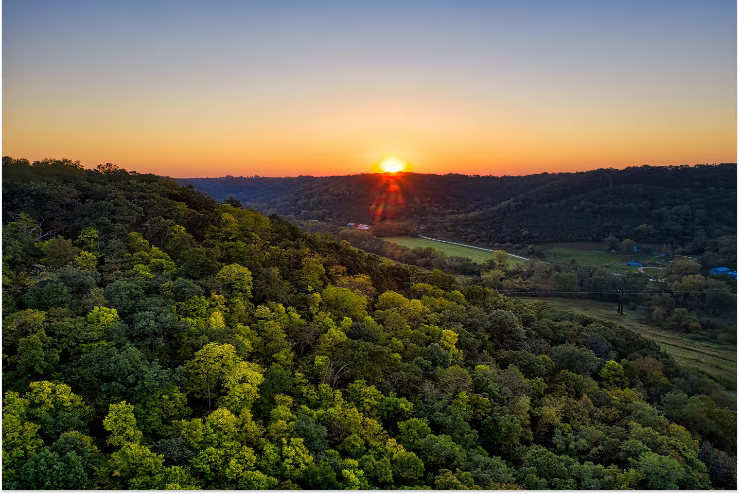 image of sun rising behind hills