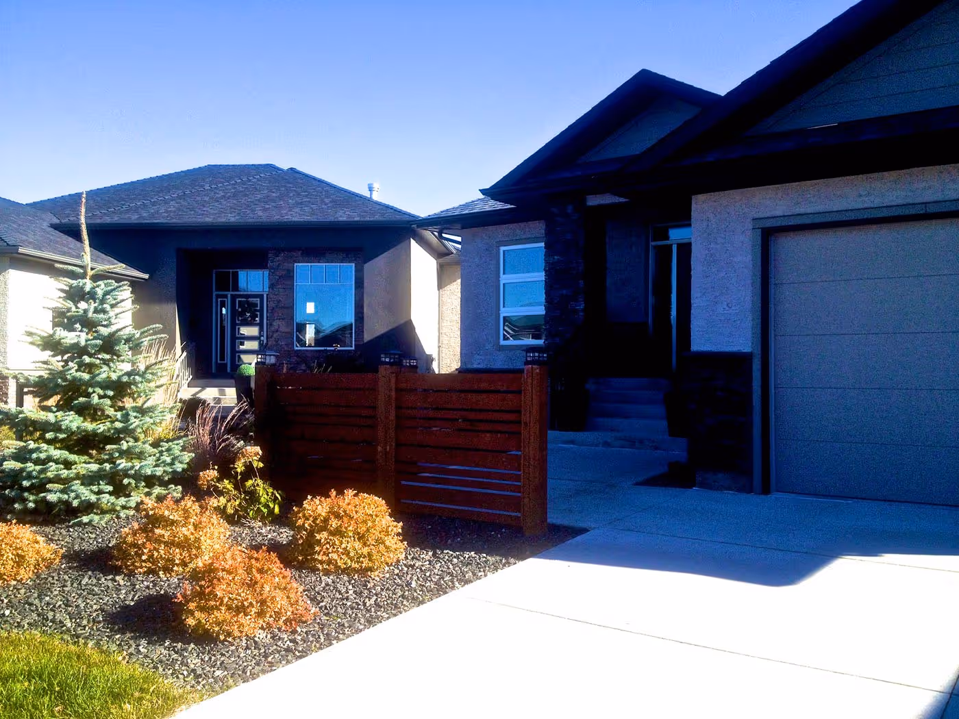 Modern Winnipeg landscaping with layered planting and hardscape