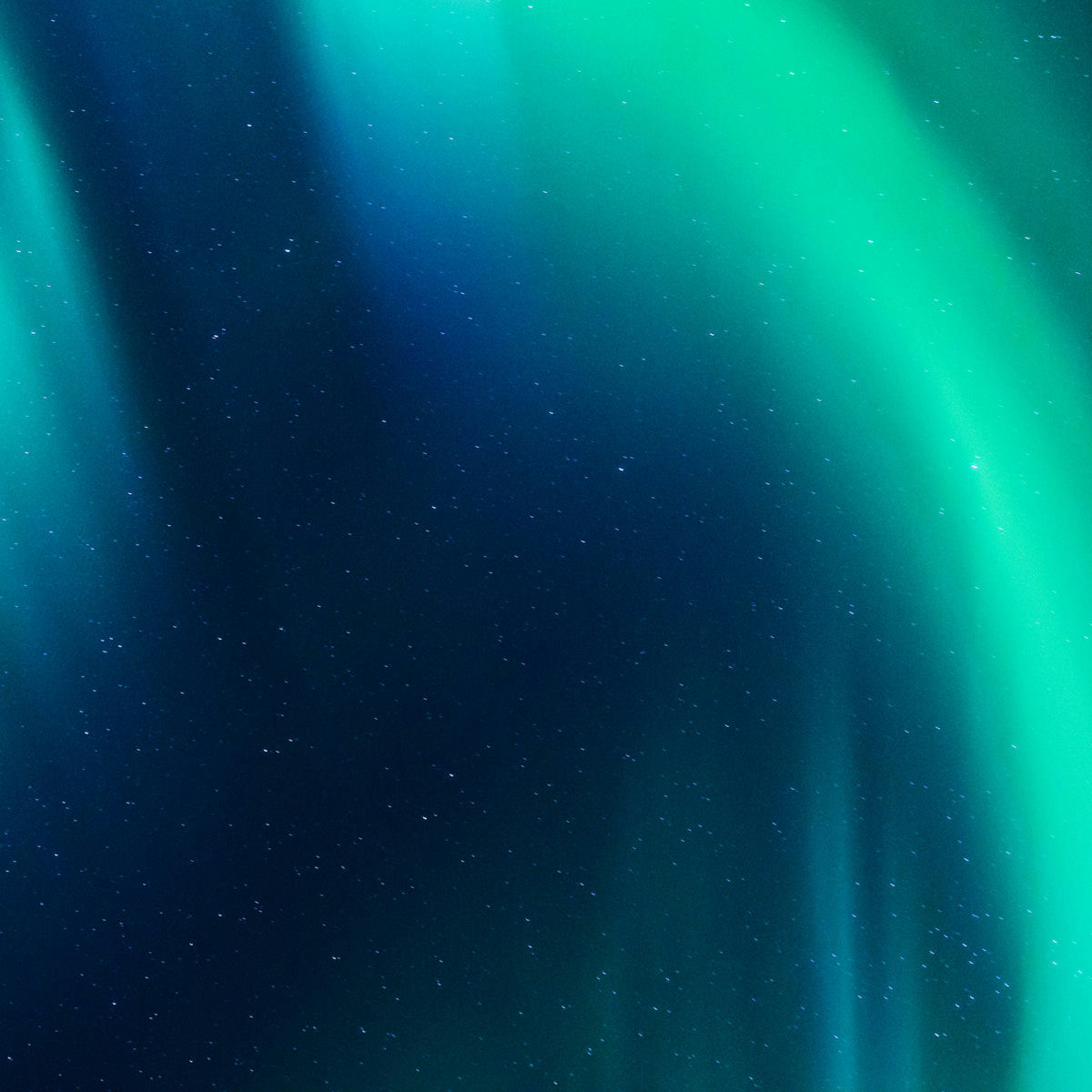 Green aurora borealis lights paint across the dark blue night sky