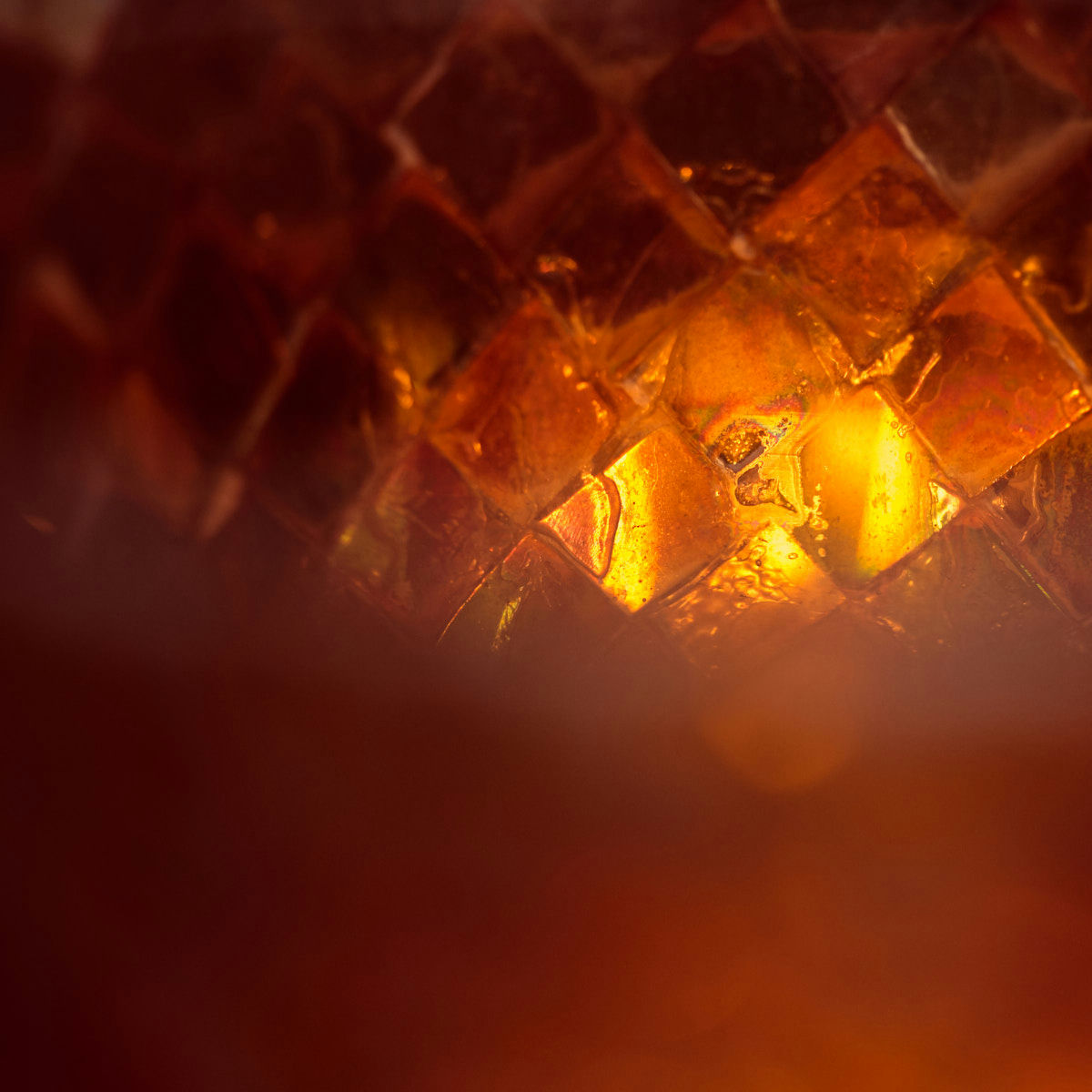 A bright orange light burns in the depths of a structure made of glass and crystal