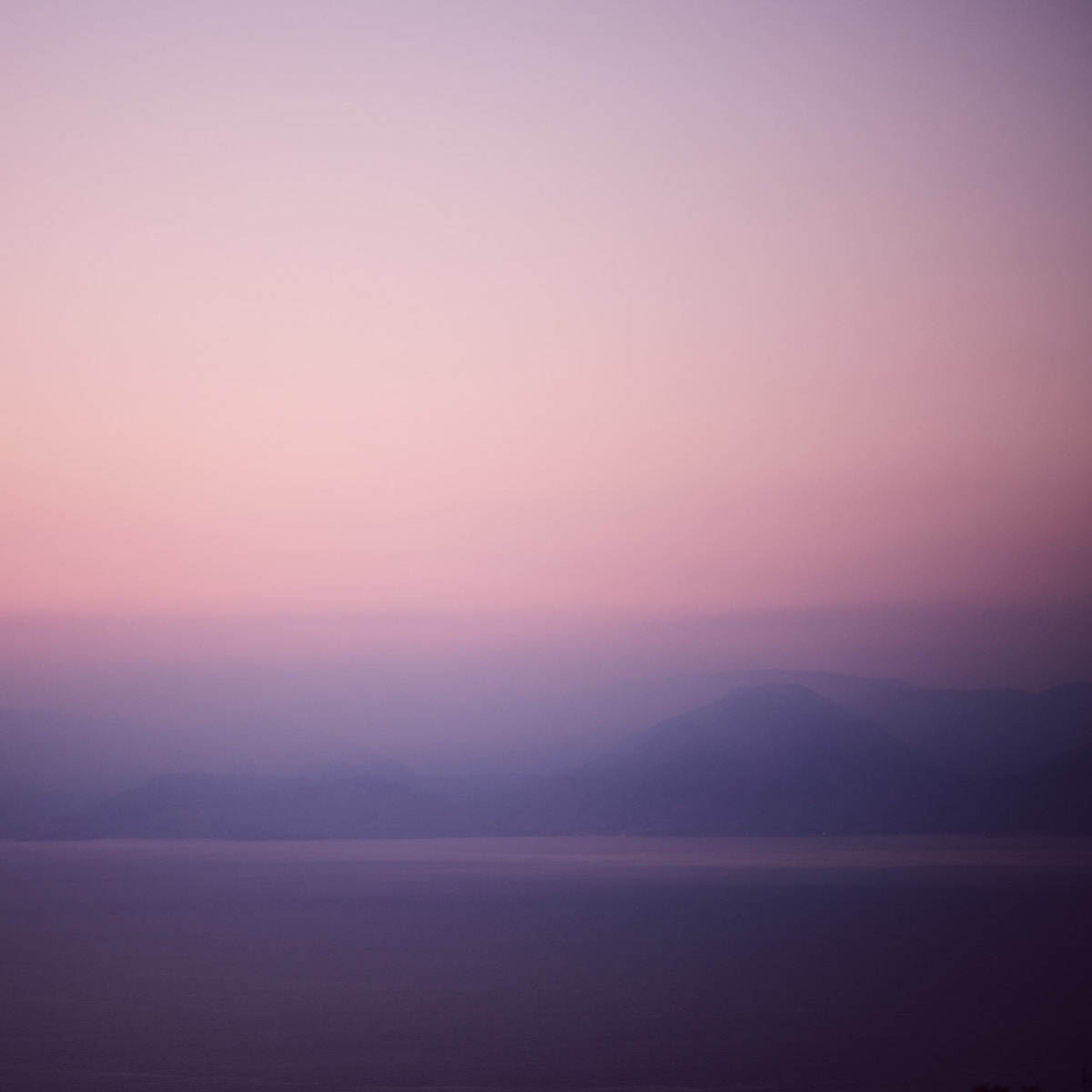 The faint outlines of mountains by the sea in the twilight 