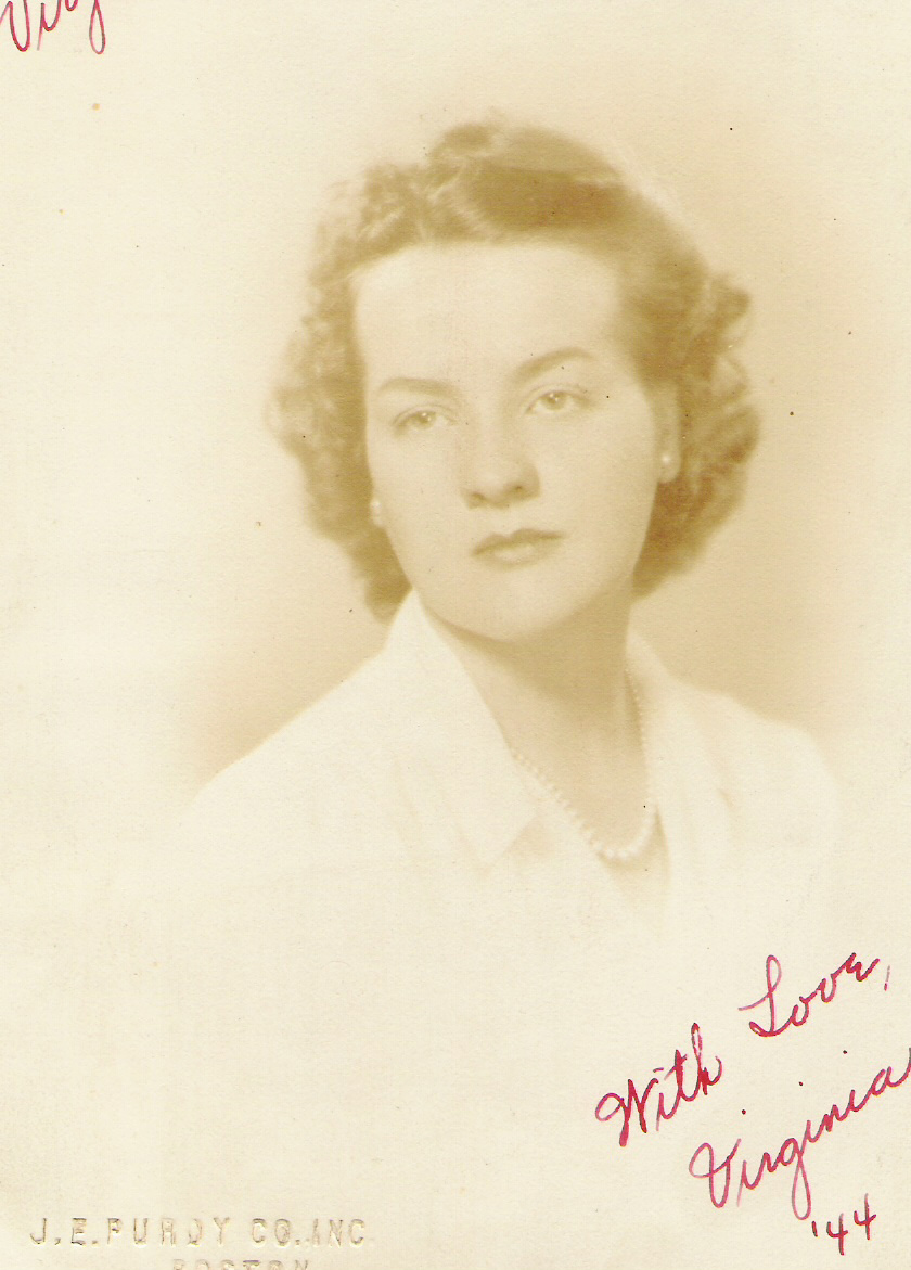 Sepia-toned portrait of a young woman with curled hair wearing a white blouse and a pearl necklace.