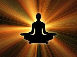 Silhouette of a person meditating in a lotus position with radiant golden light rays spreading outward.