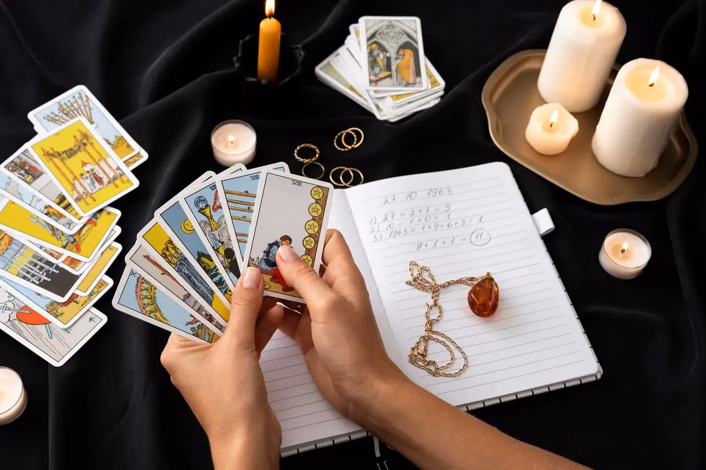 A woman holds a tarot card in one hand and a lit candle in the other, creating a mystical atmosphere. 