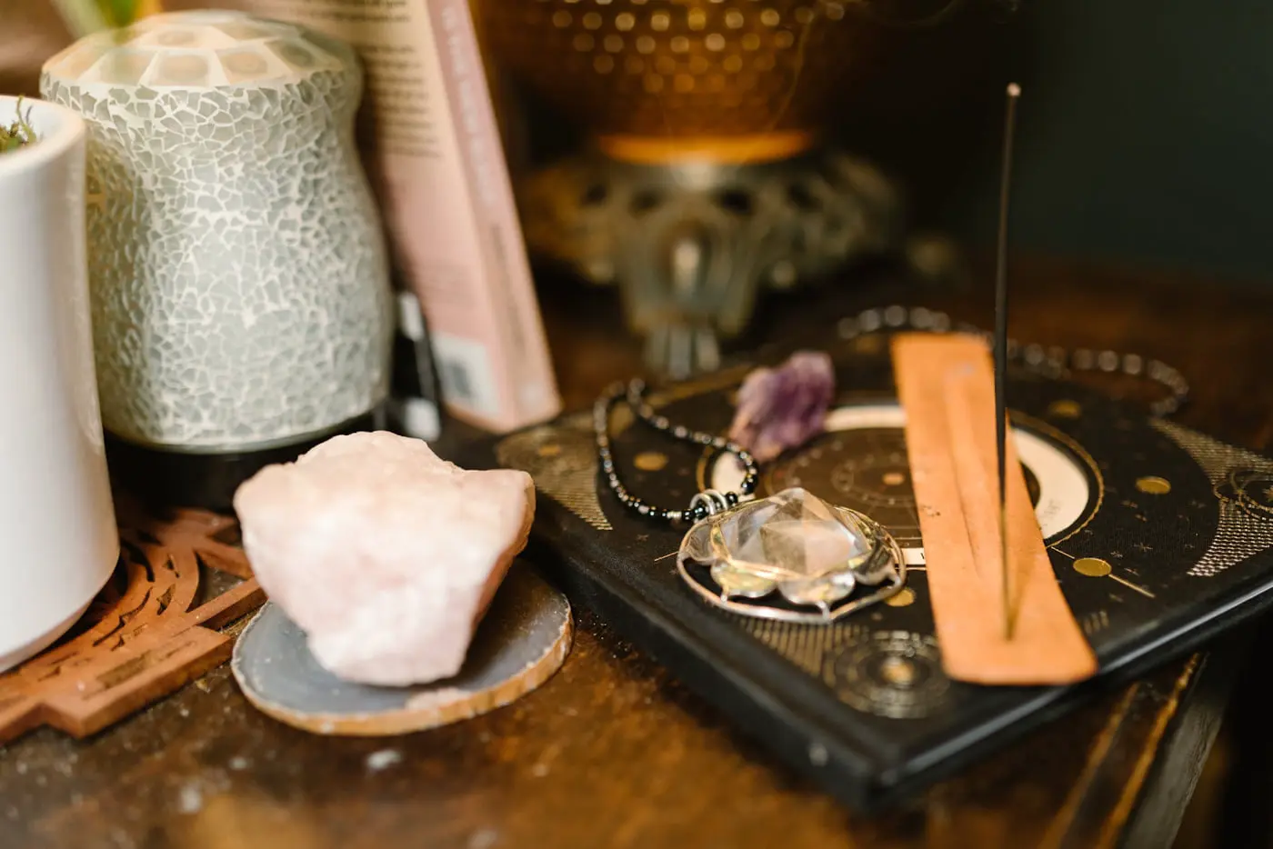 A table displaying a crystal, an open book, and a lit candle, creating a serene and inviting atmosphere.