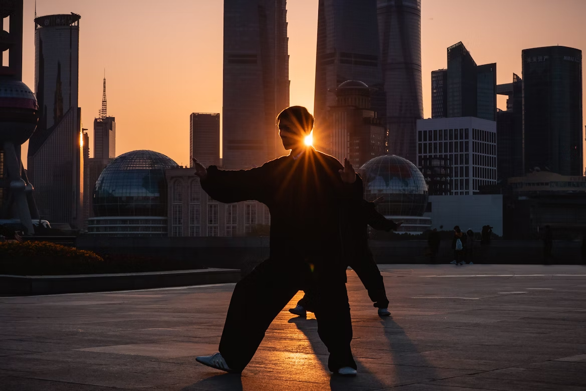 A couple of Tai Chi masters welcome the new day against the Lujiazui skyline in Downtown Shanghai