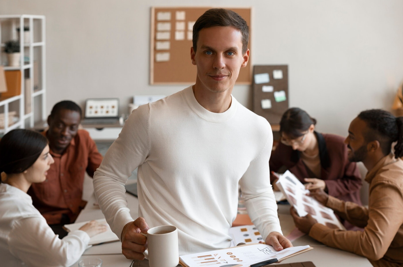 A man stands confidently in front of a group of people, engaging them with his presentation. 