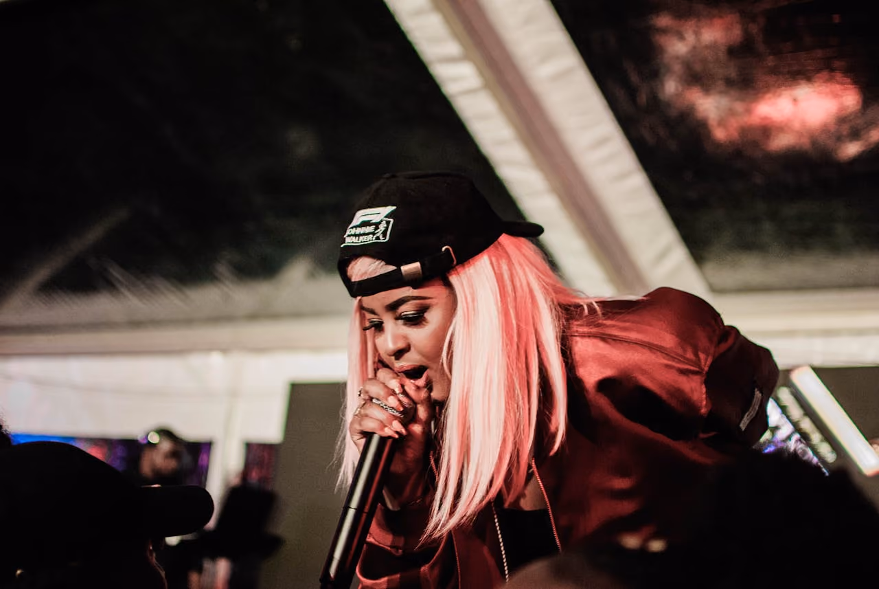 A woman commanding a stage with a microphone — representing the legacy of female rap artists who changed hip-hop culture.