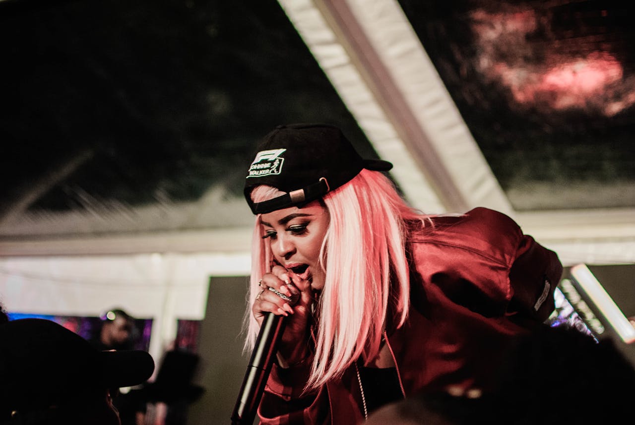 A woman commanding a stage with a microphone — representing the legacy of female rap artists who changed hip-hop culture.