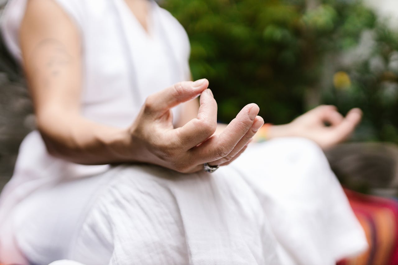 woman seated outside doing a chakra meditation