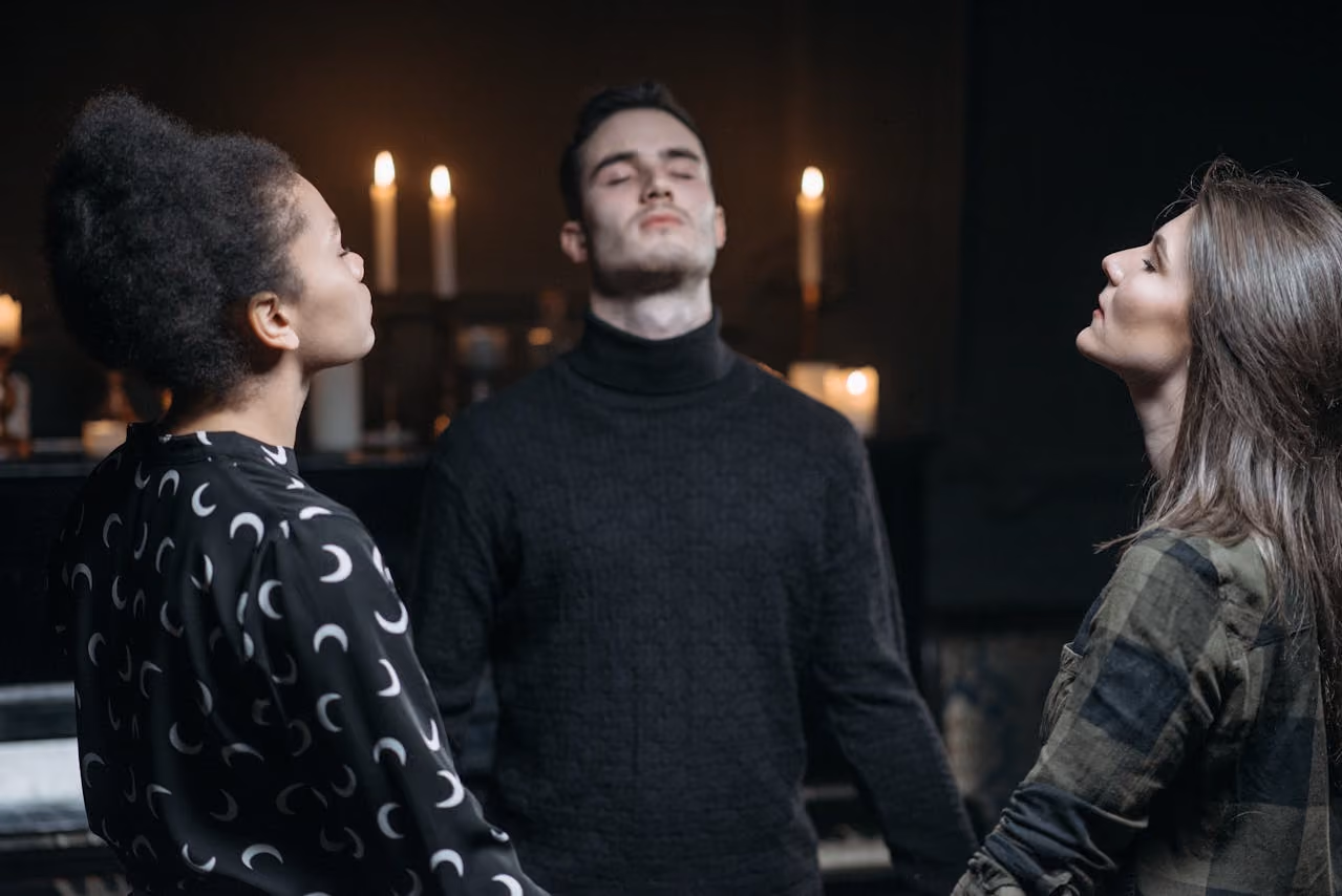 group of three spiritual practioners holding hands in a circle