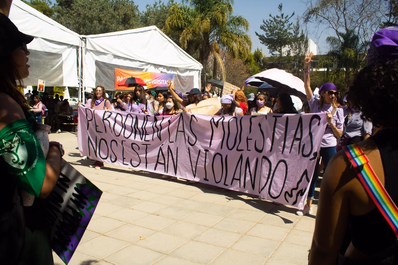 Women carrying a banner down the street during a protest
