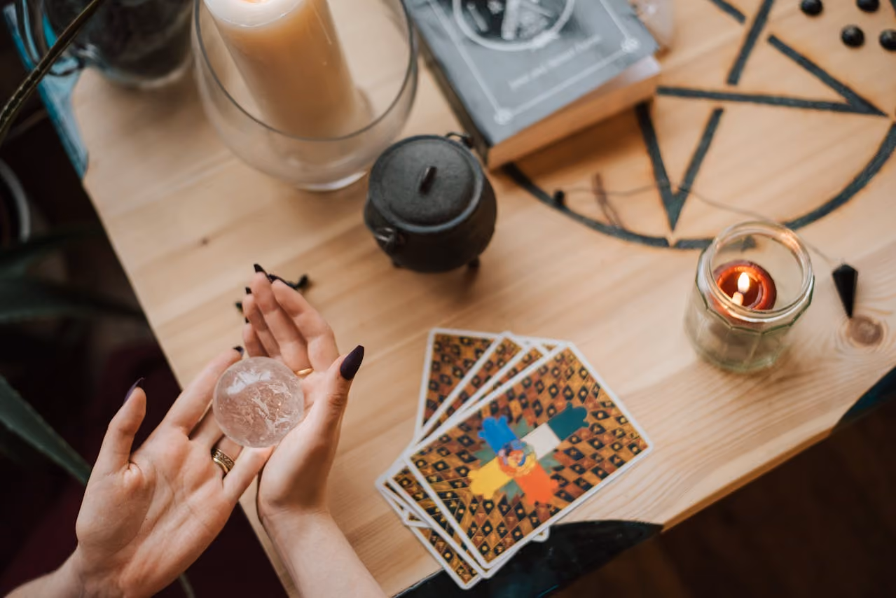 Tarot card spread on an altar including candles, stones, and other spiritual tools