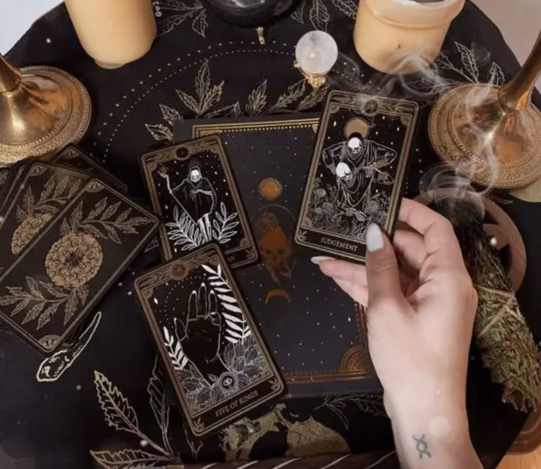 woman laying out a tarot spread and looking at the page of swords