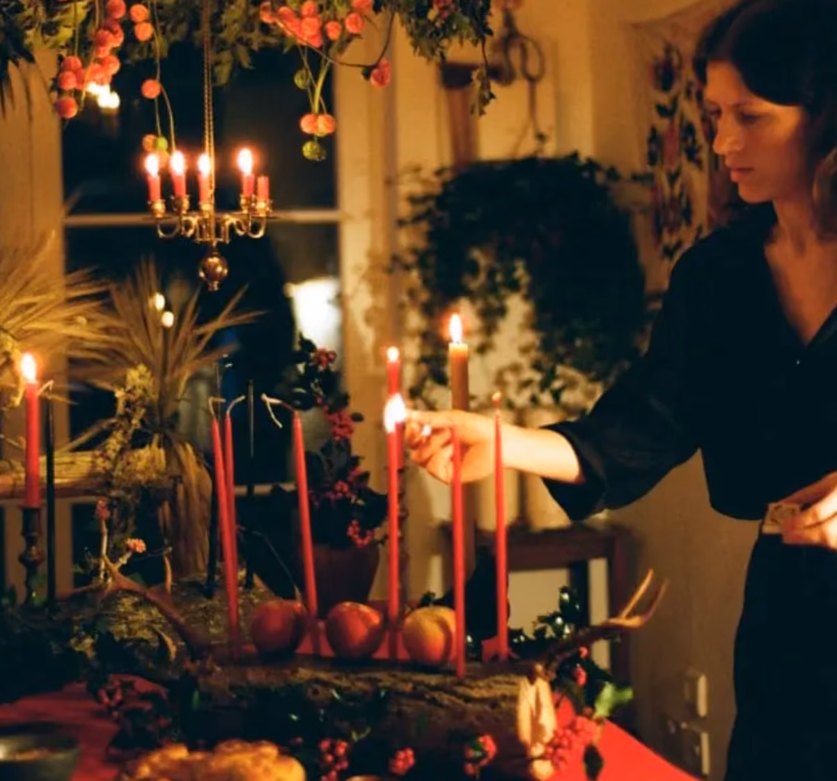 woman lighting candles as a celebration of Yule