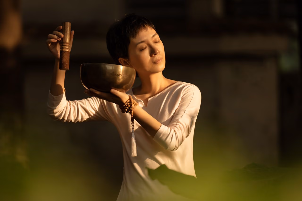 woman using bowls to create a sound bath as a spiritual grounding technique