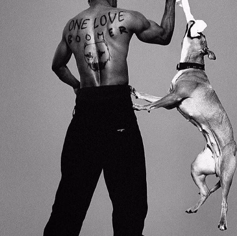 Rapper DMX's shows off his back tattoo, which reads ONE LOVE BOOMER and features a portrait of his dog, whom he is playing with in the black and white photo