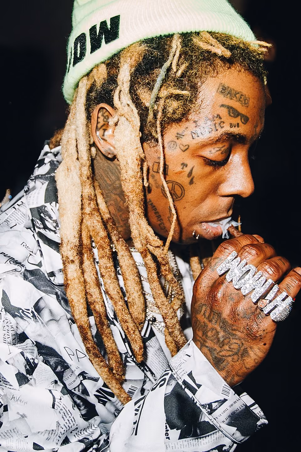 a close up of Lil Waynes face in profile, showing some of his iconic face tattoos including Bub, Baked, I am music, teardrops, and hearts