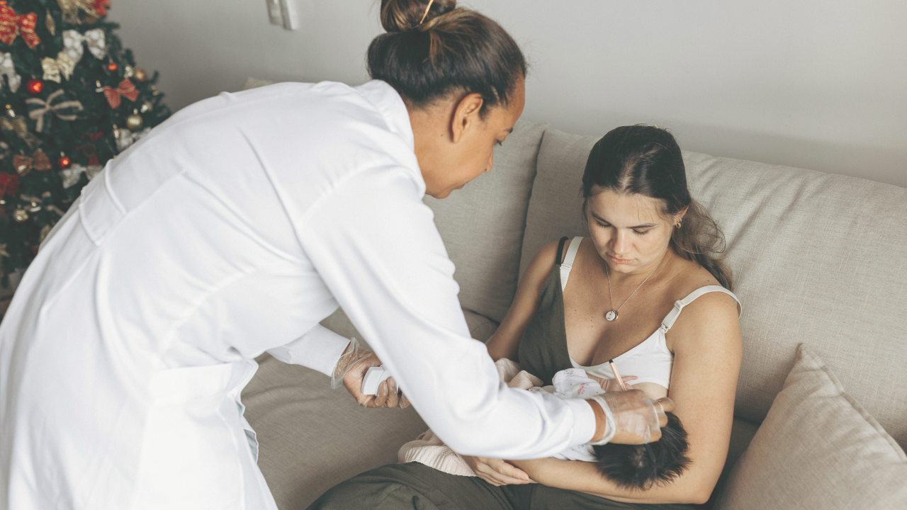 woman receiving help with her baby from a doula