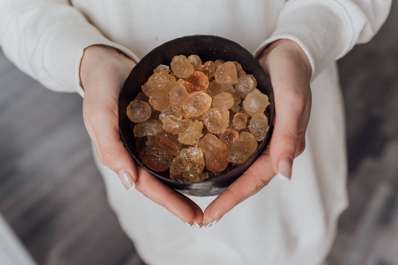 woman holding a bowl of citrine stones, reflecting on the spiritual meaning of citrine