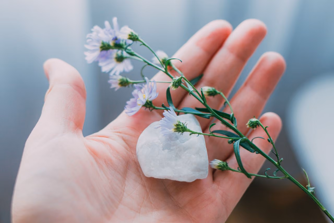 woman holding moonstone in her palm, contemplating the spiritual meaning of the stone