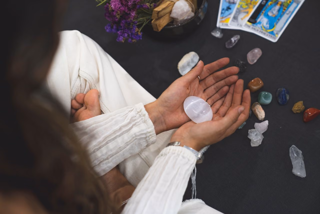 woman holding an opalite crystal in her hands as she reflects on the meaning of the stone