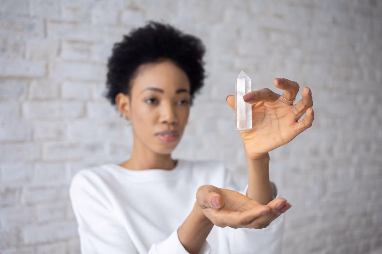 spiritual practitioner holding a cleansing selenite crystal during meditation 