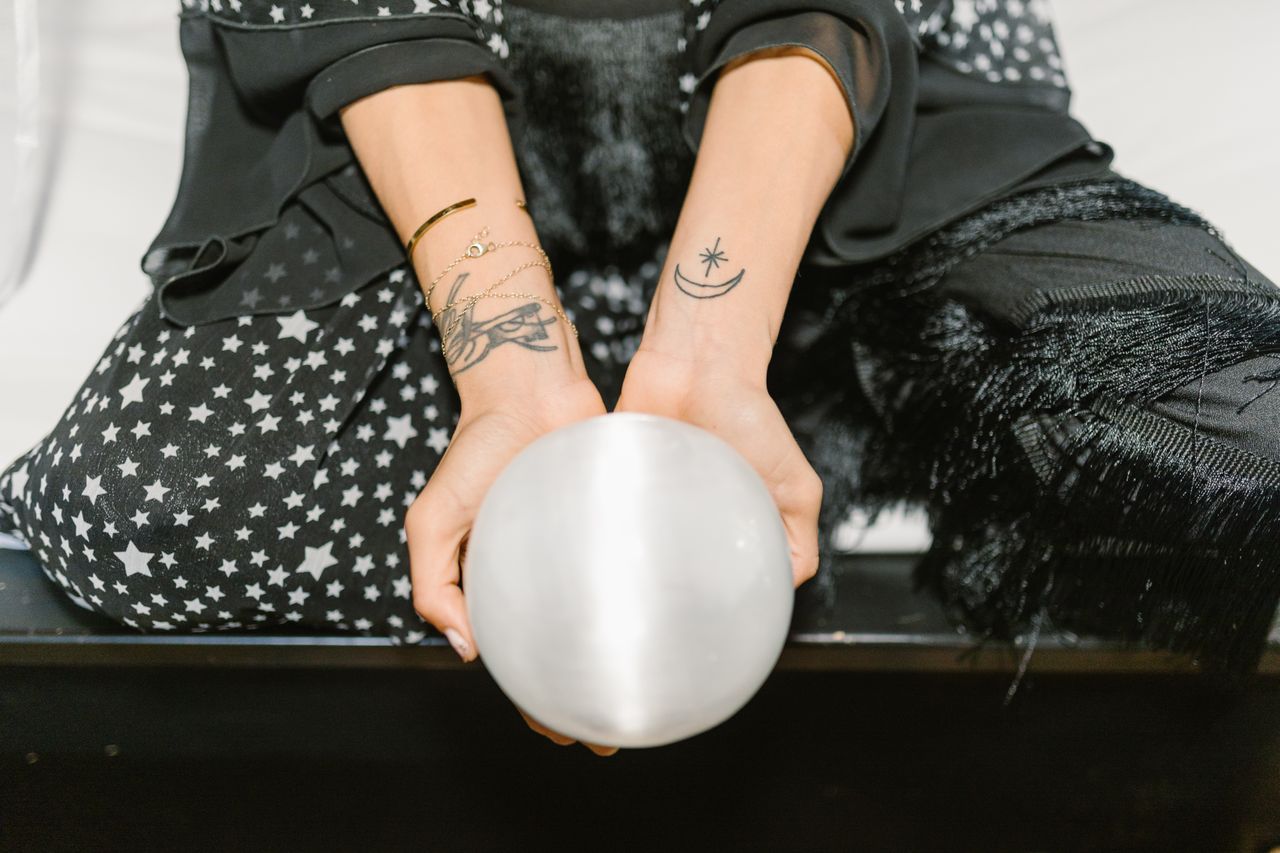 woman holding a smooth, softly luminous selenite crystal ball