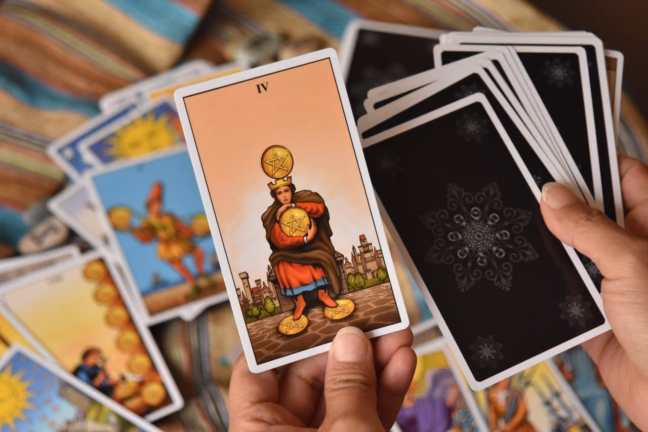 A spread of Minor Arcana tarot cards on a dark surface — representing the 56 cards of everyday experience that form the heart of a tarot reading.