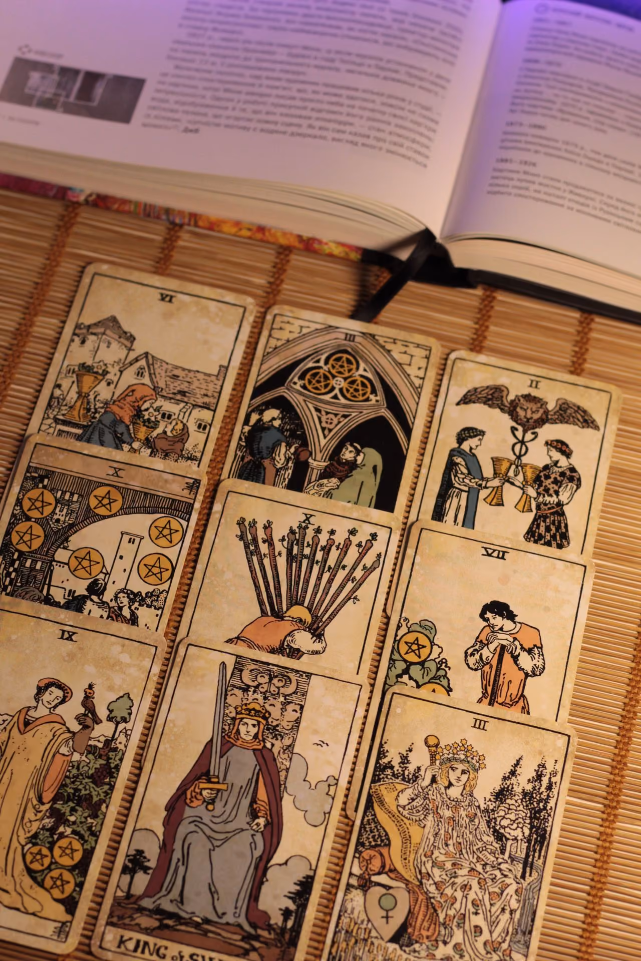 tarot reading spread out on a table with an open book about tarot card meanings nearby