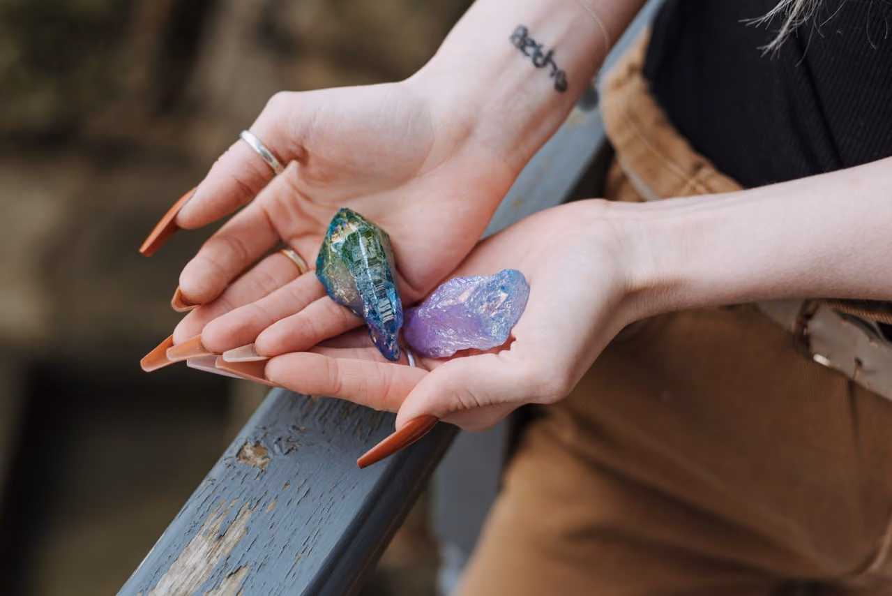 woman holding irridescent metal coated crystals in her open palms