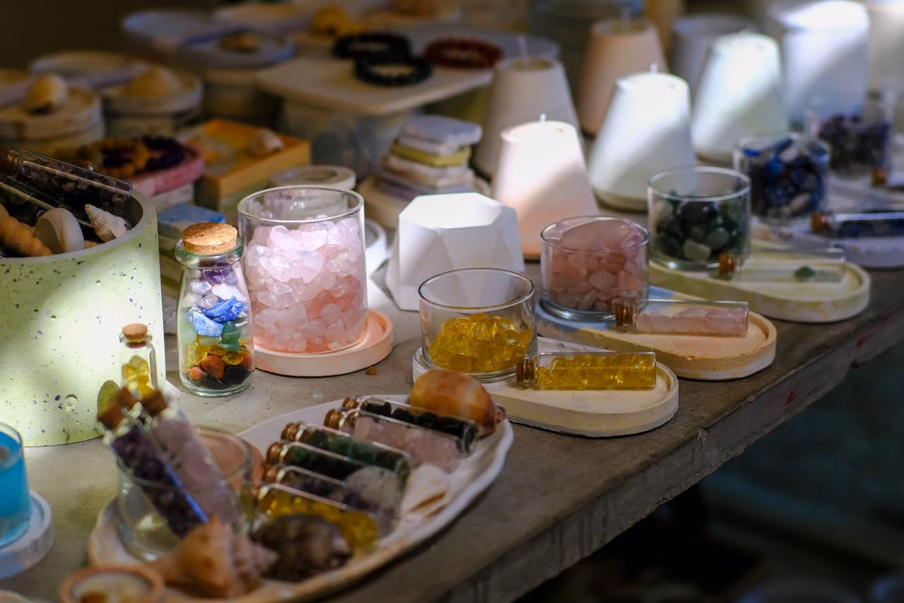 display at a crystal shop with gemstones in different colors arranged in cups and small vials