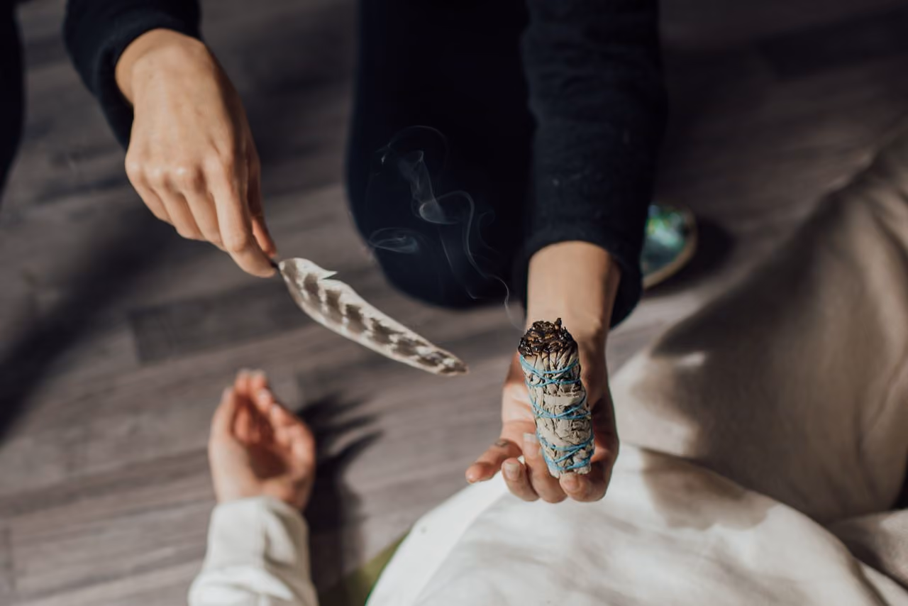 sage smudging ritual using an eagle feather and abalone shell
