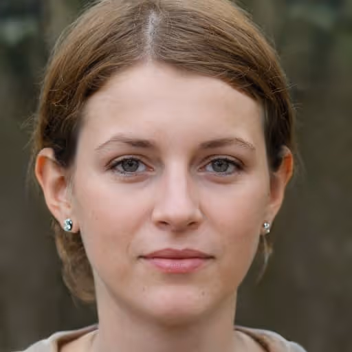 Close-up portrait of a woman with light brown hair, gray eyes, and stud earrings, looking directly at the camera with a neutral expression.