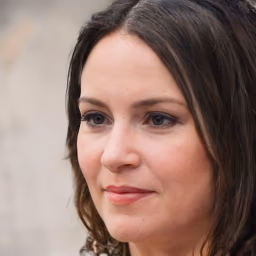 Close-up portrait of a woman with shoulder-length brown hair and natural makeup, looking slightly to the side.