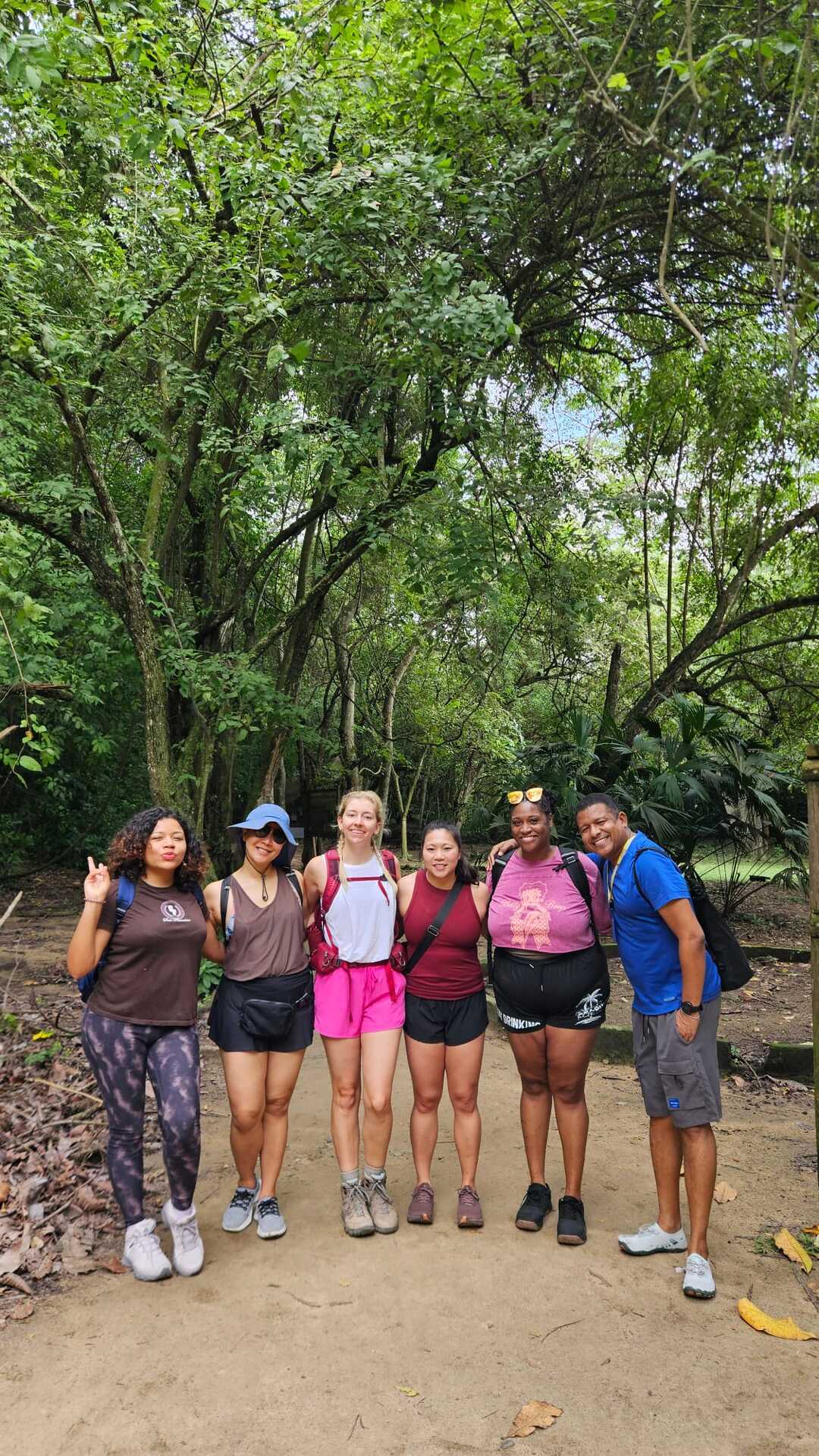 Group of travelers standing together on a jungle path in Tayrona National Park, Colombia.