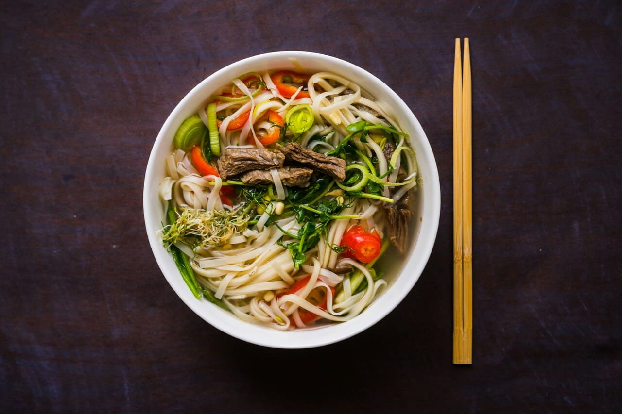 Traditional Vietnamese pho noodle soup with beef, fresh herbs, and vegetables.
