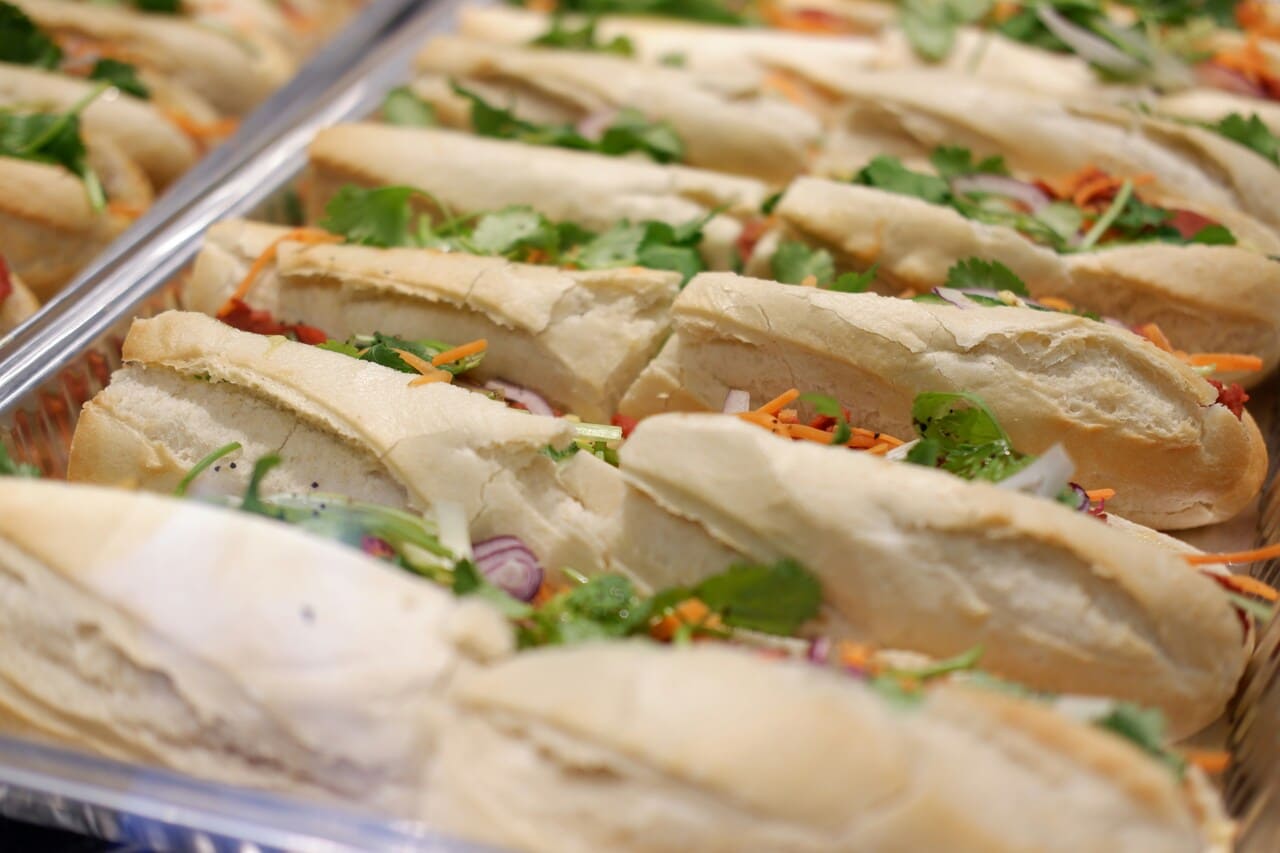 Fresh Vietnamese banh mi sandwiches filled with herbs, vegetables, and meat.