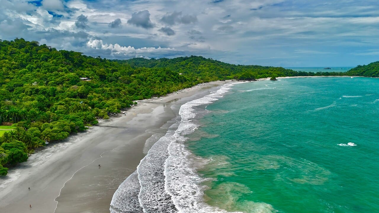 Aerial view of Manuel Antonio beach with lush rainforest and the Pacific Ocean in Costa Rica.