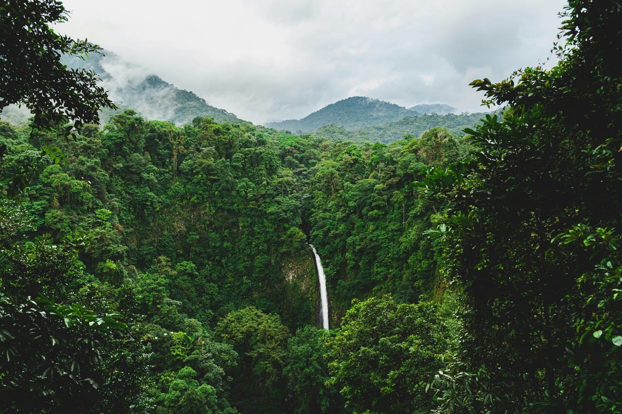 La Fortuna Waterfall surrounded by lush rainforest near Arenal Volcano in Costa Rica