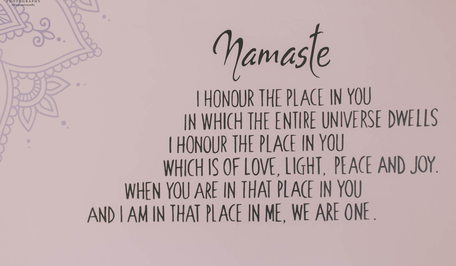 A mural on a wall at a yoga studio that says "namaste" with a description of its meaning
