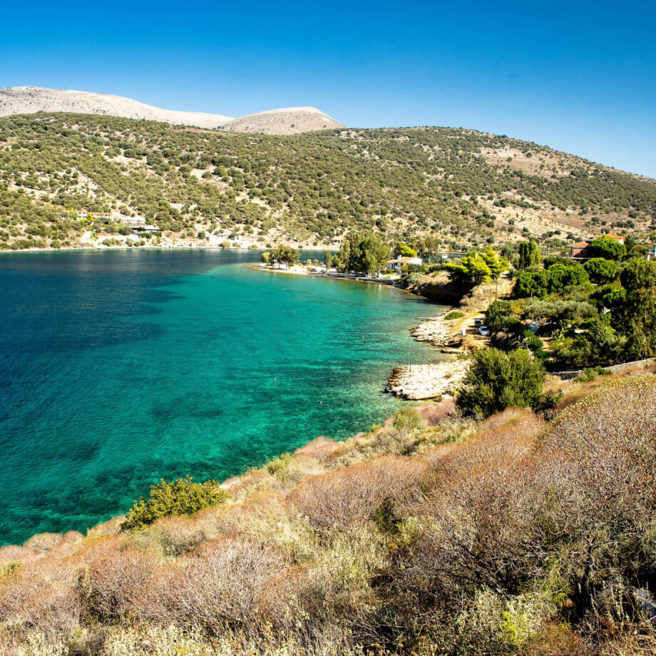 A landscape view overlooking green mountains and crystal clear sea waters in Evia, Greece