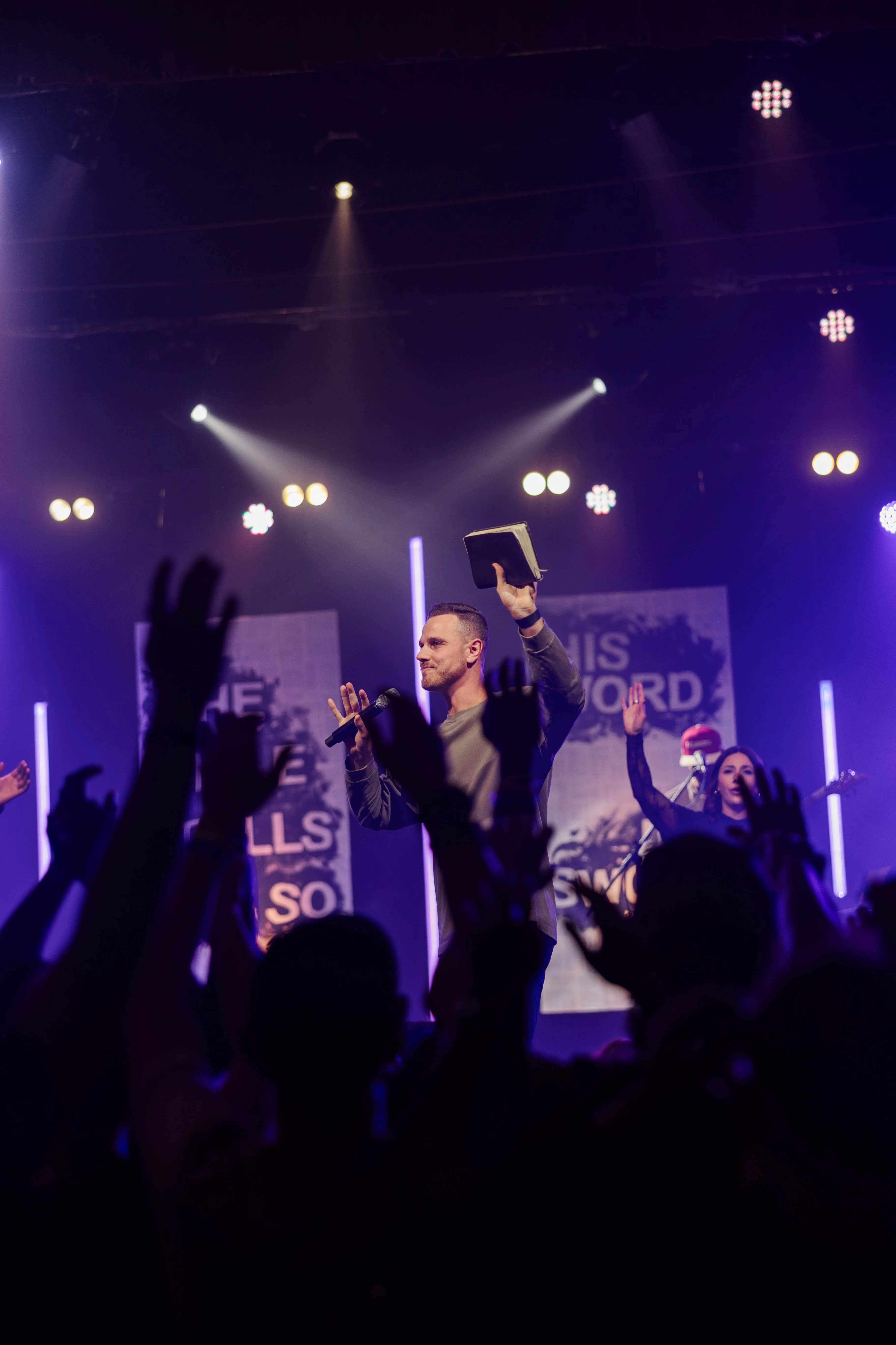 A speaker holding a Bible during CrossWalk Youth Conference 2025.