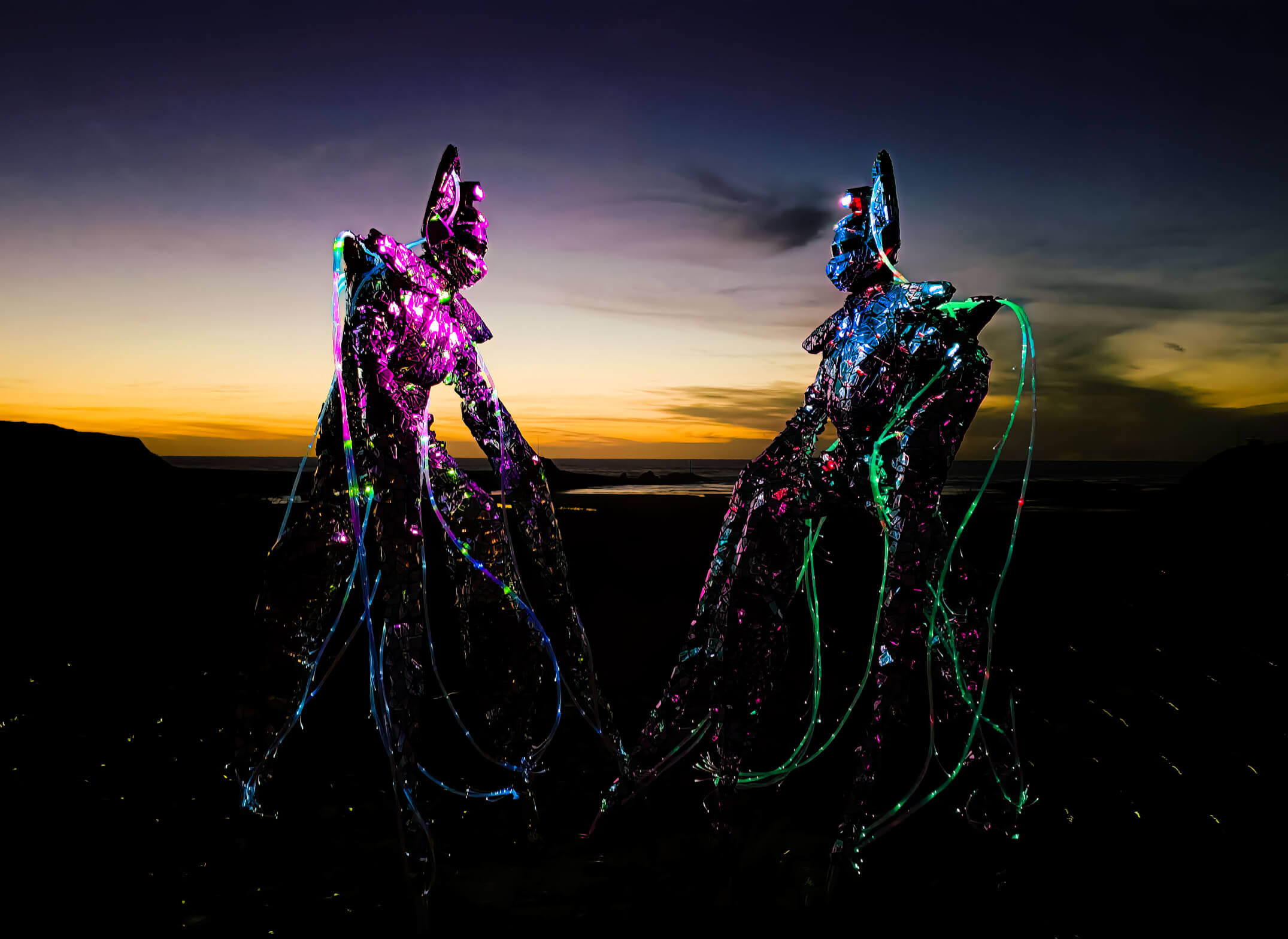 Stiltwalking illuminated aliens.