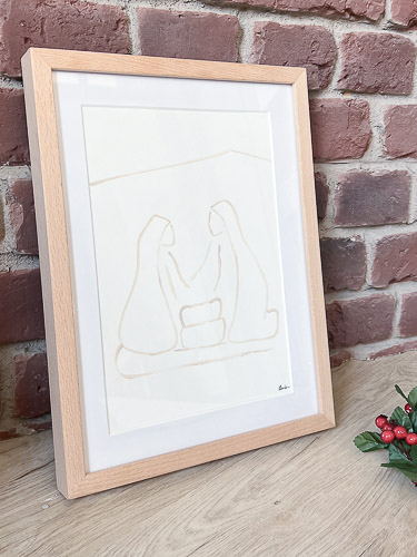 Lámina serie Nacimiento color beige, enmarcada en marco de haya sobre camarera