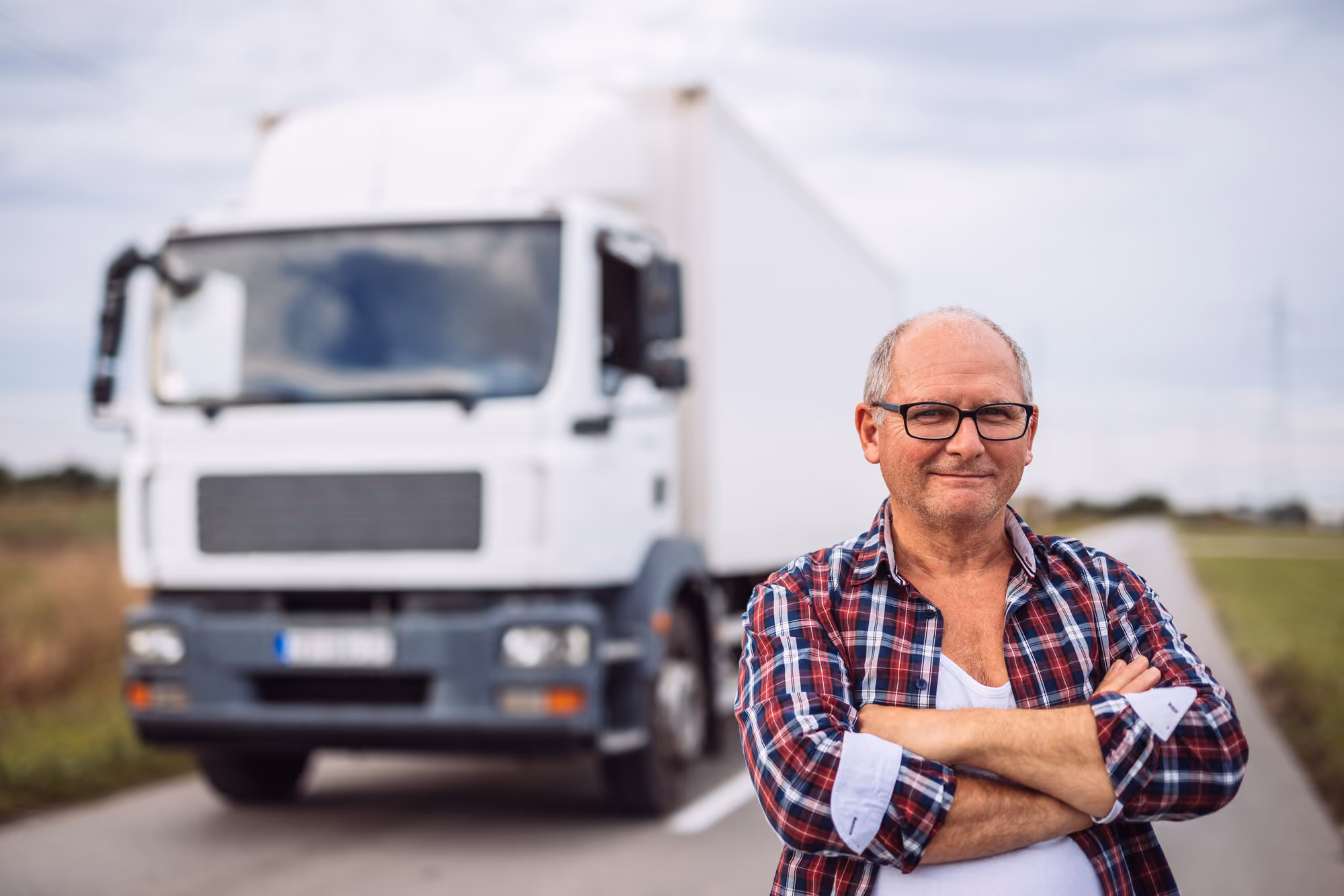 Un camionero se pone delante de su camión
