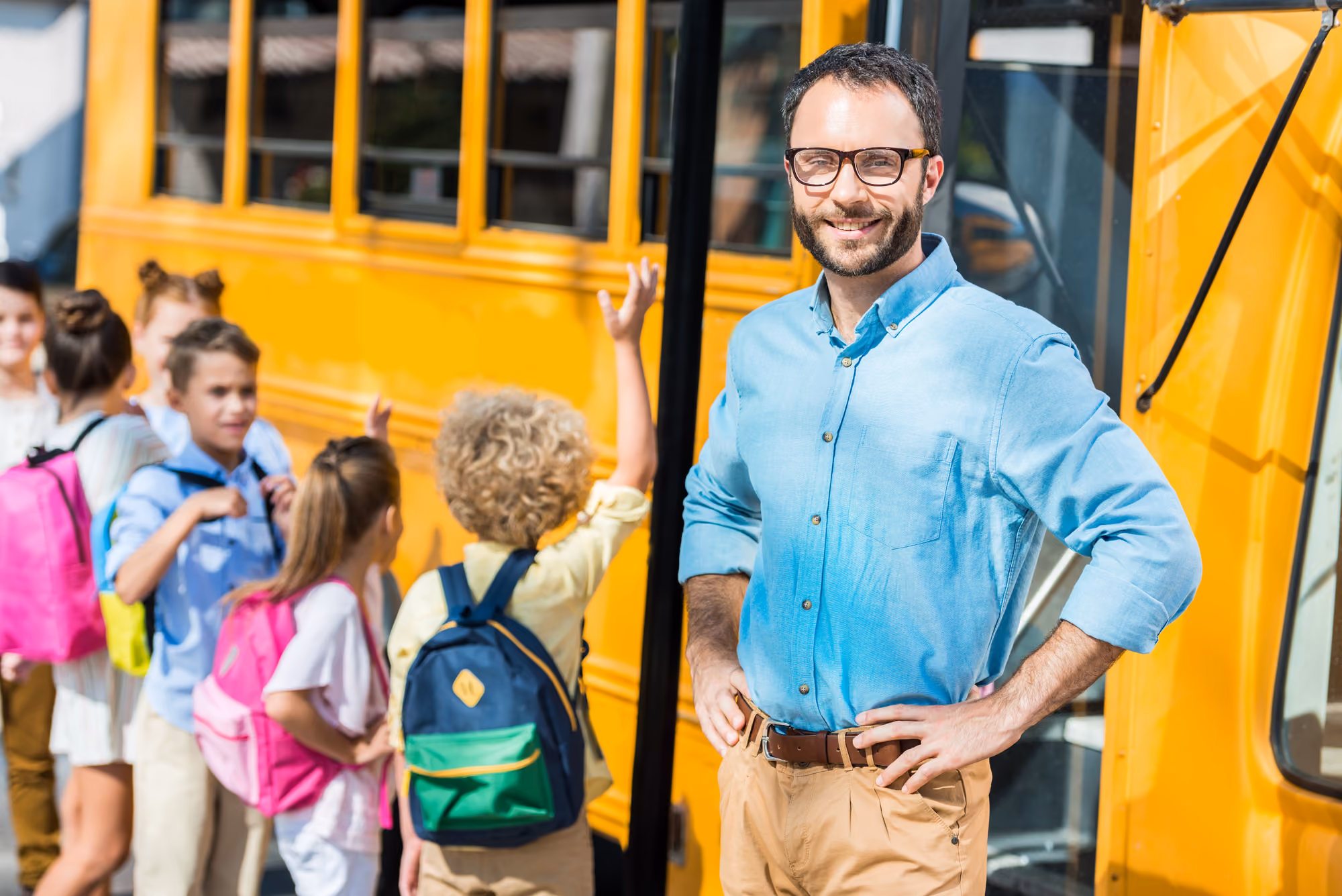 School bus driver with students boarding the bus