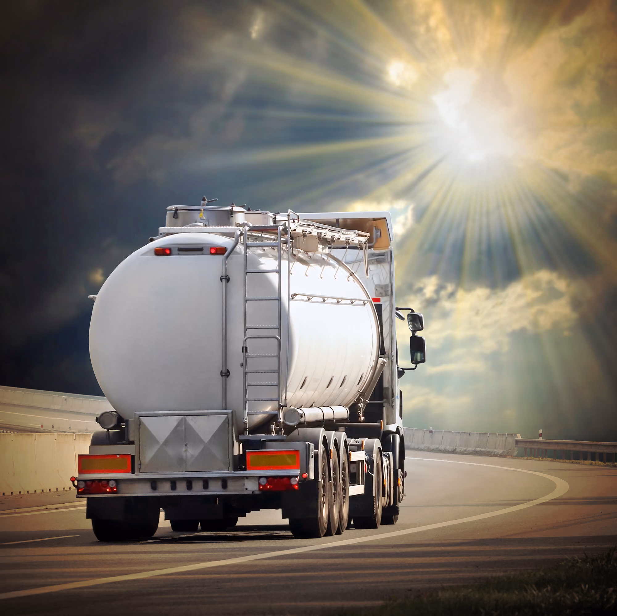 A tanker truck drives into the horizon